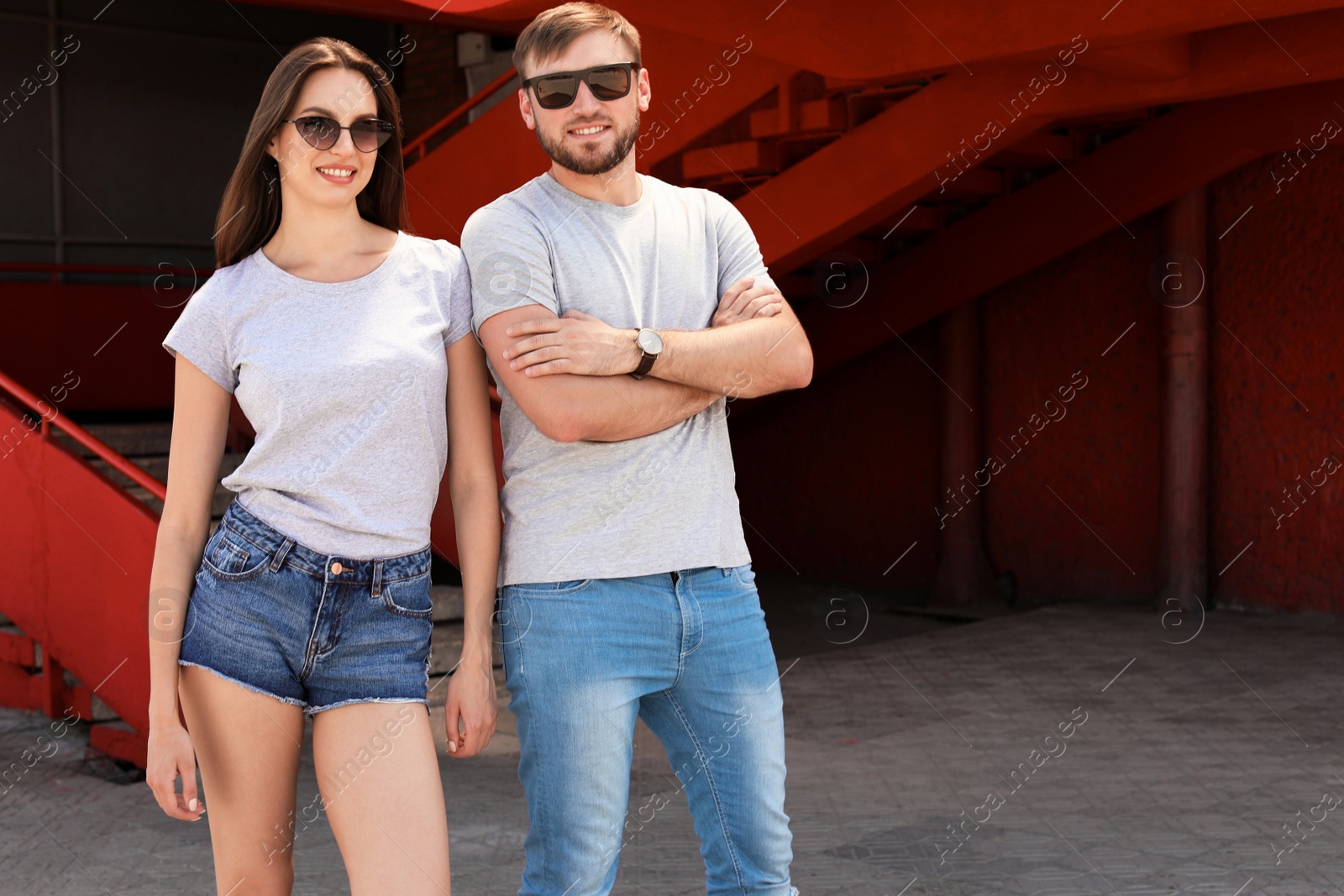 Photo of Young couple wearing gray t-shirts on street