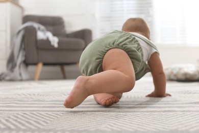Photo of Cute baby crawling at home, focus on legs