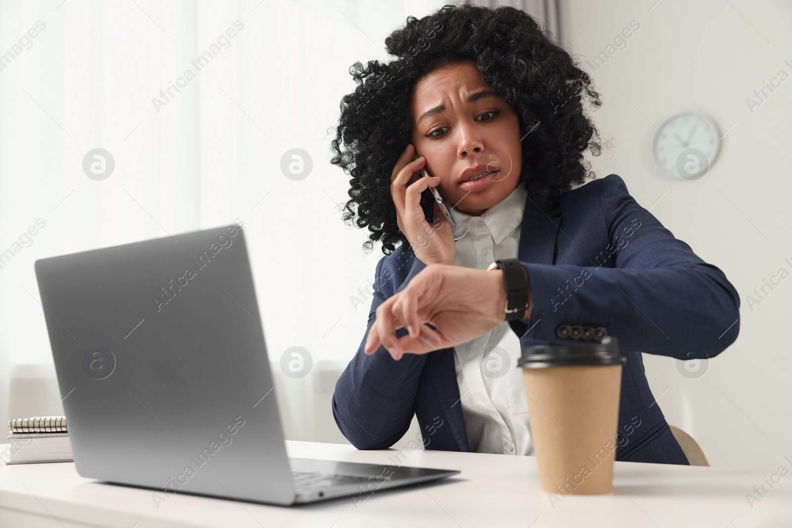 Photo of Deadline concept. Scared woman talking on smartphone and checking time in office