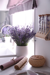 Photo of Beautiful lavender flowers on countertop near sink in kitchen