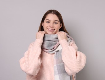 Photo of Beautiful woman in warm scarf on gray background