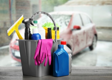 Image of Bucket with cleaning supplies on white wooden surface at car wash