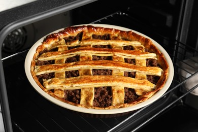 Photo of Delicious meat pie in oven, closeup view