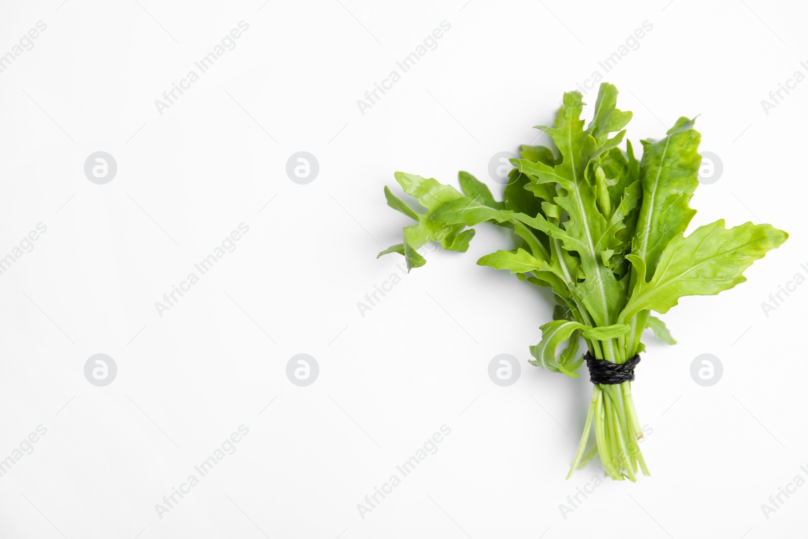 Photo of Fresh arugula on white background, top view. Space for text