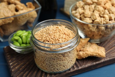 Dehydrated soy meat and other organic products on blue table, closeup