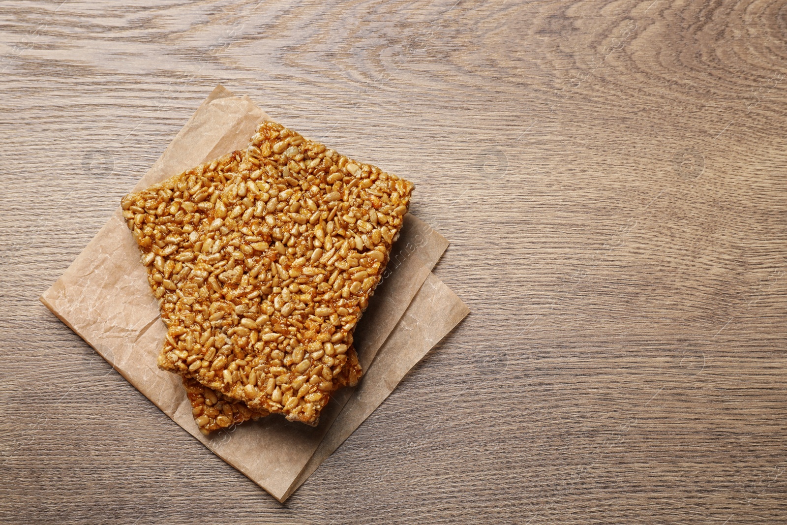 Photo of Delicious kozinaki bars on wooden table, top view Space for text