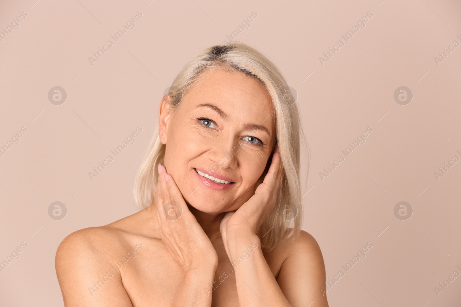 Photo of Portrait of beautiful mature woman on beige background