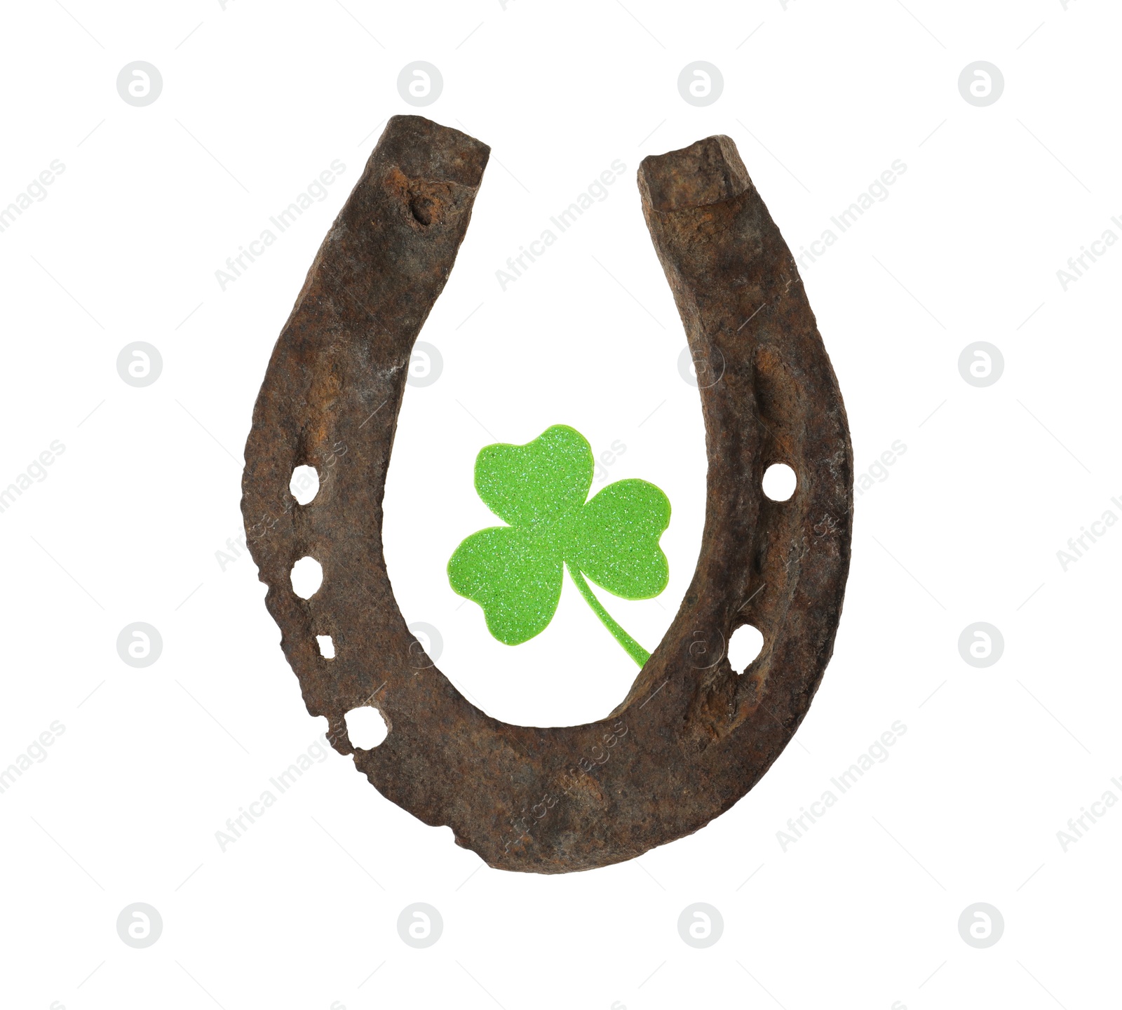 Photo of Old horseshoe and clover on white background. St. Patrick's Day celebration