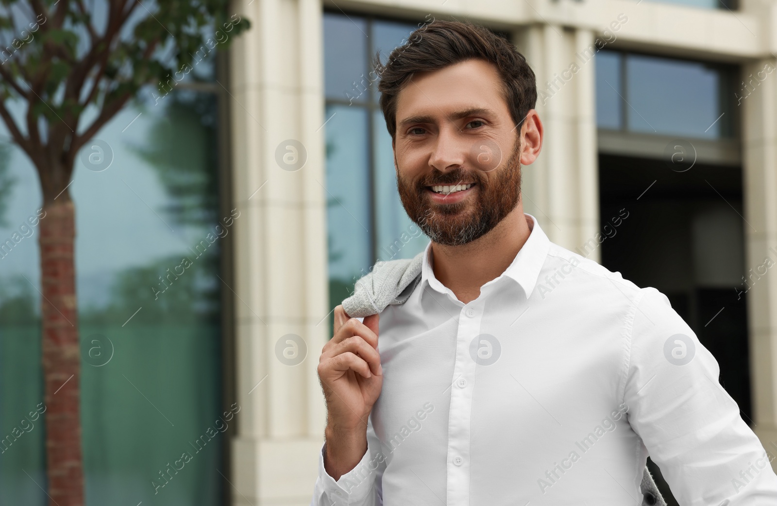 Photo of Portrait of handsome bearded man on city street, space for text