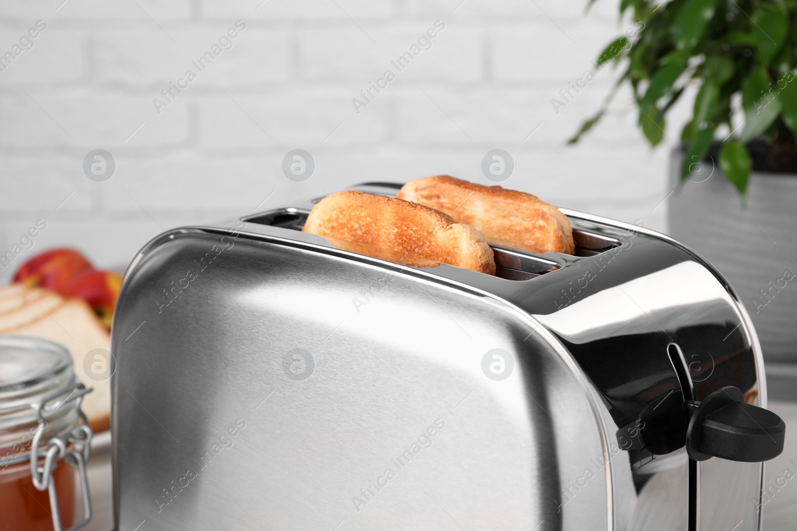 Photo of Tasty roasted bread in toaster indoors, closeup