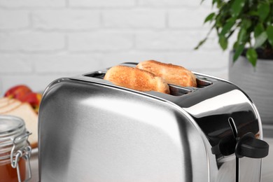 Photo of Tasty roasted bread in toaster indoors, closeup