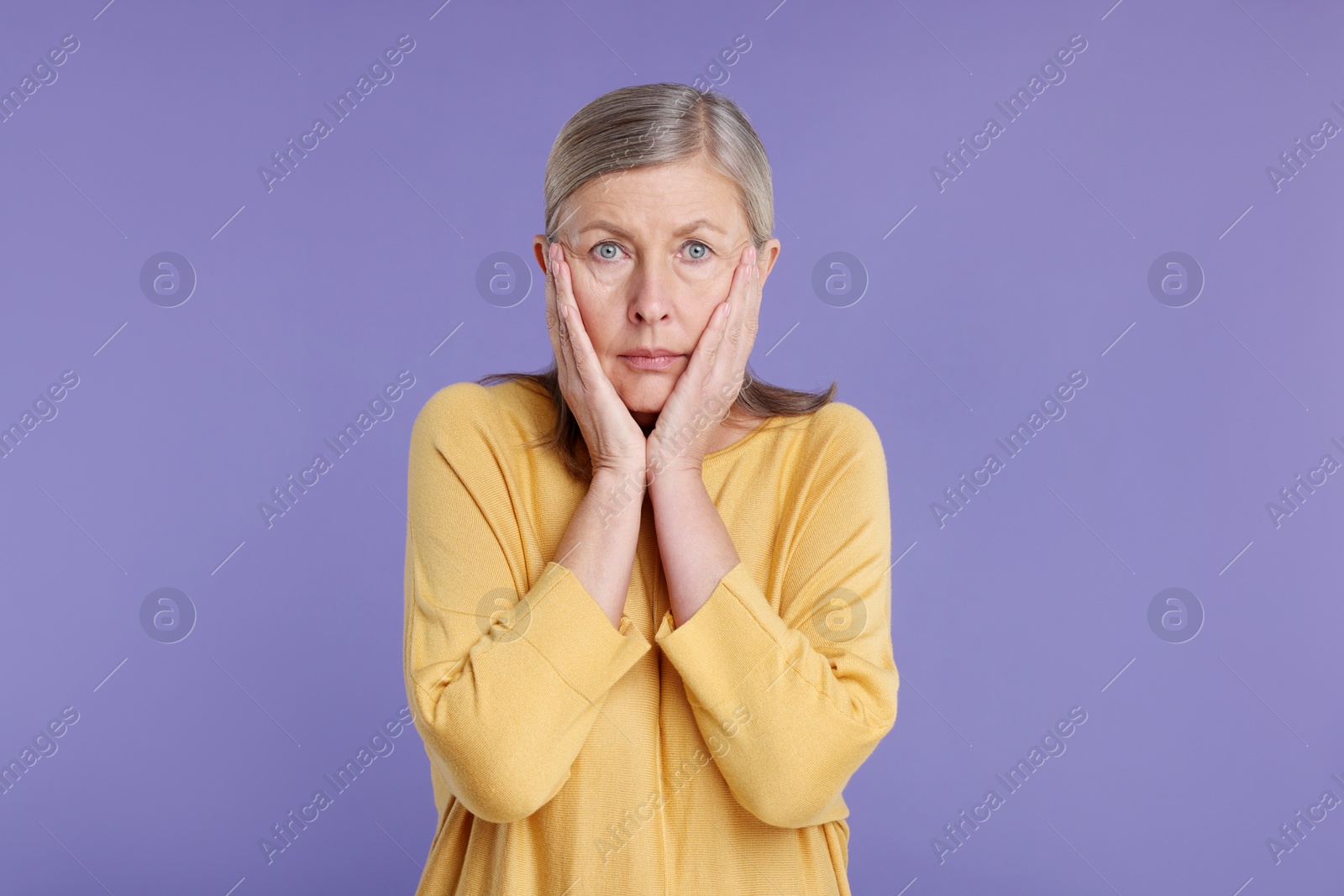 Photo of Portrait of surprised senior woman on violet background