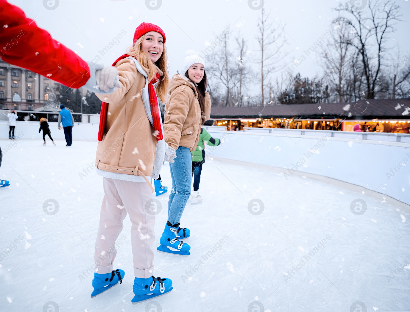 Image of Group of friends skating at outdoor ice rink