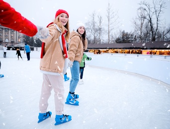 Group of friends skating at outdoor ice rink