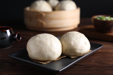 Photo of Delicious Chinese steamed buns on wooden table, closeup