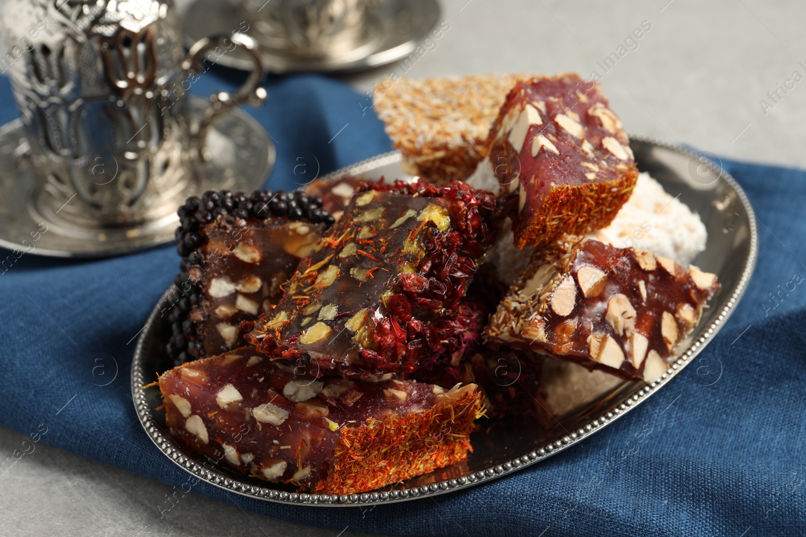 Photo of Tea and Turkish delight served in vintage tea set on grey table, closeup