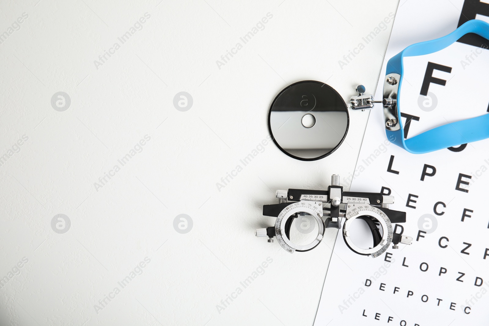 Photo of Different ophthalmologist tools on white table, flat lay. Space for text