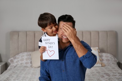 Photo of Little boy greeting his dad with Father's Day at home