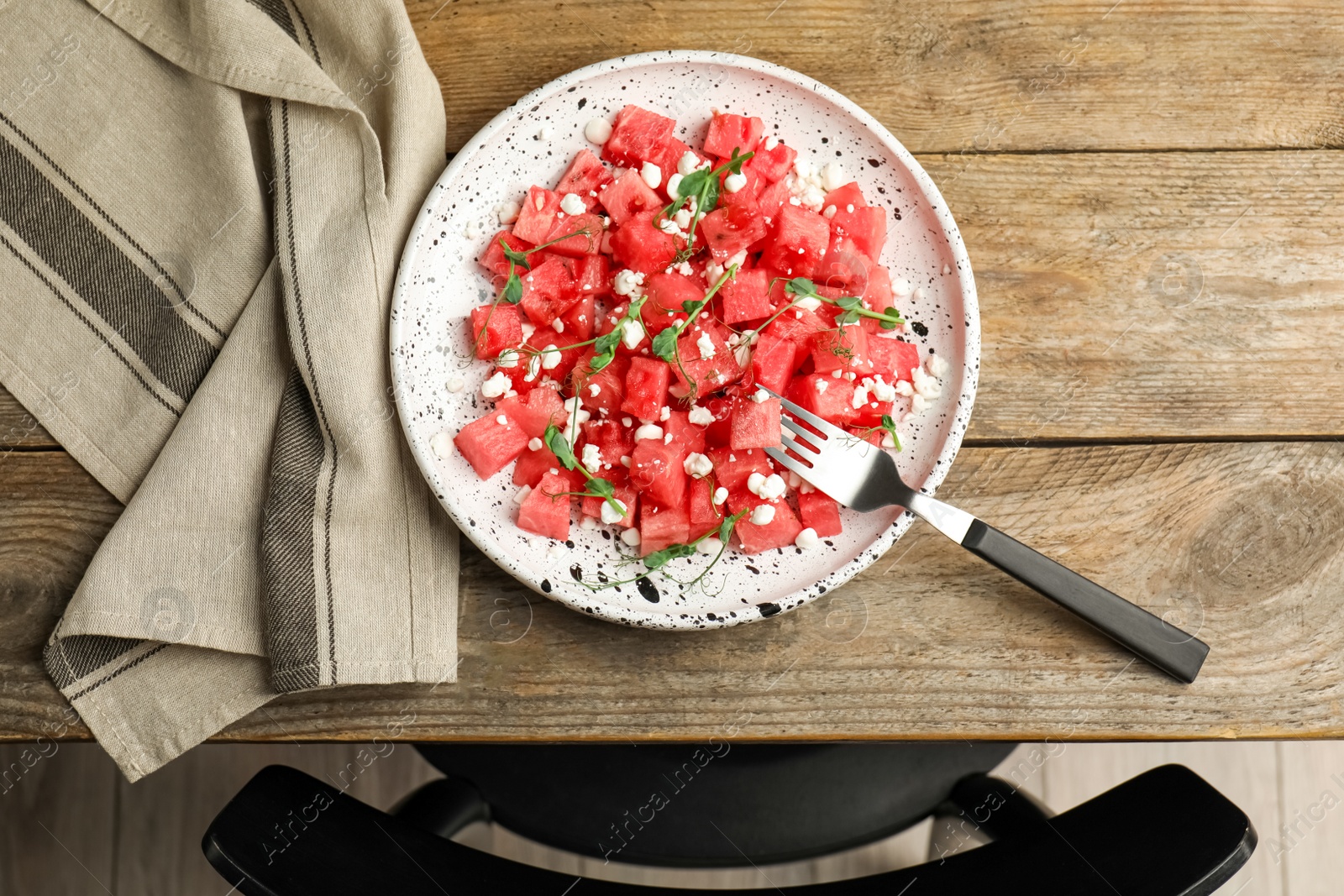 Photo of Delicious salad with watermelon served on wooden table indoors, flat lay