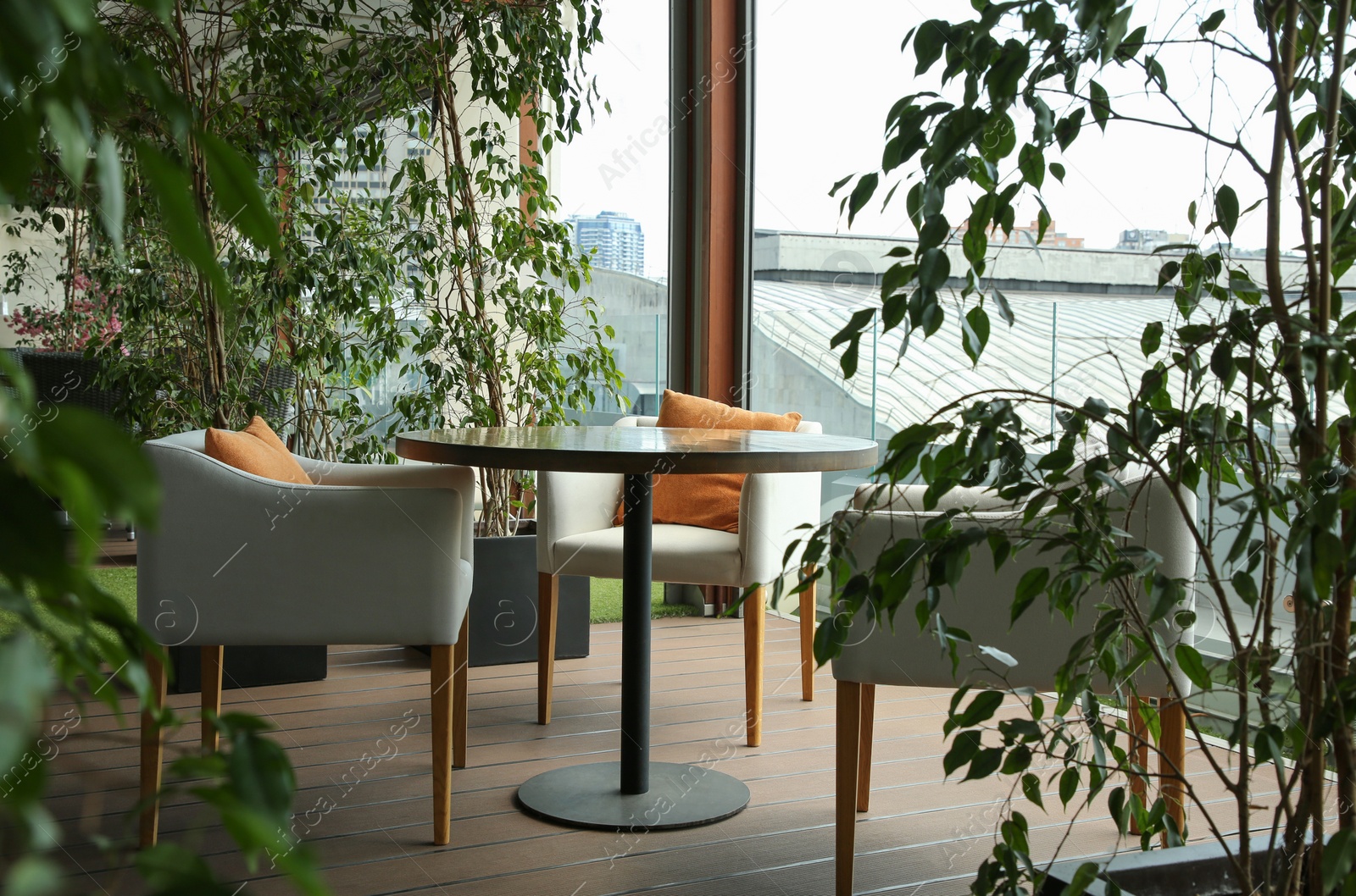 Photo of Observation area cafe. Table, armchairs and green plants on terrace