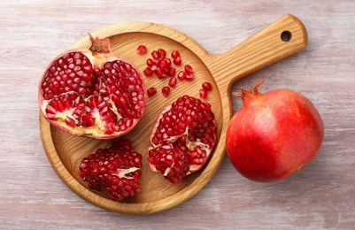 Photo of Fresh pomegranates on wooden table, top view