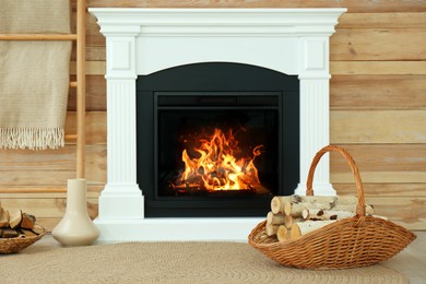 Photo of Firewood in wicker basket near fireplace indoors