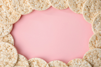 Photo of Frame made of puffed rice cakes on pink background, flat lay. Space for text