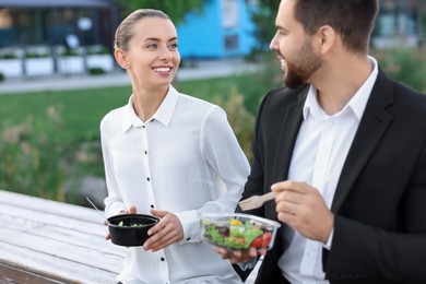 Photo of Smiling business woman talking with her colleague during lunch outdoors