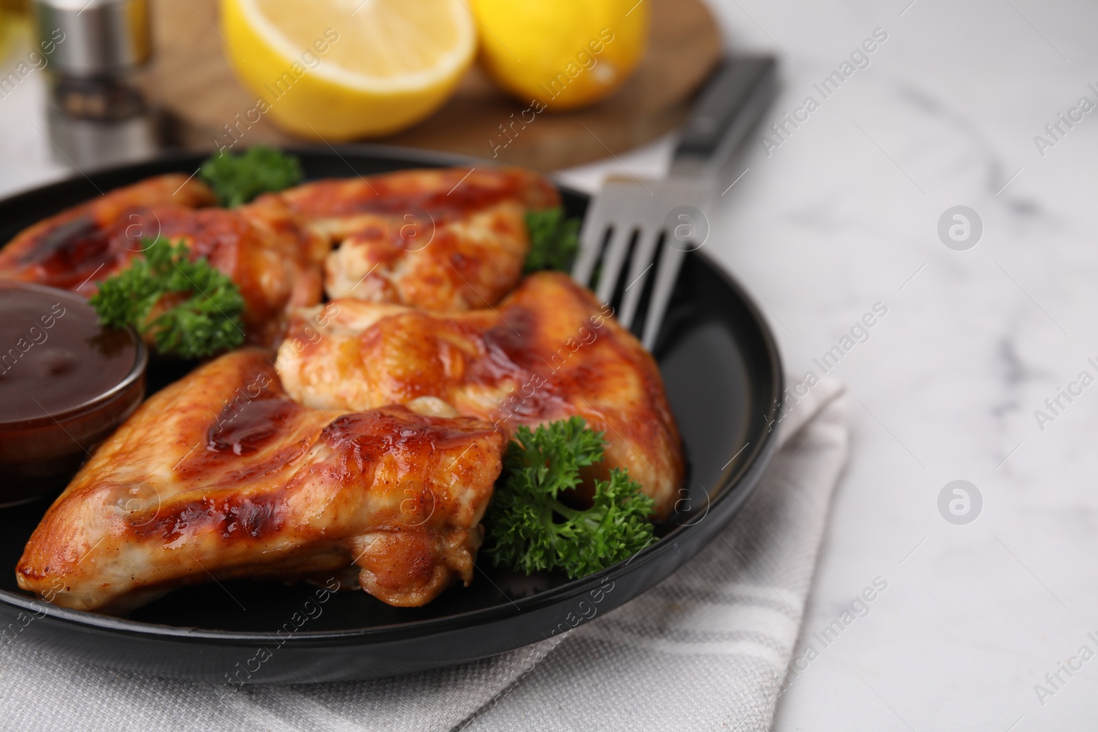 Photo of Fresh marinade and chicken wings on white table, closeup. Space for text