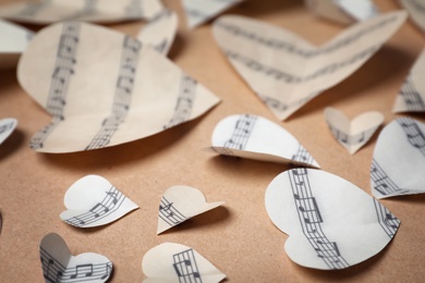 Paper hearts with music notes on color background