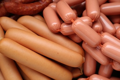 Different tasty sausages as background, closeup view