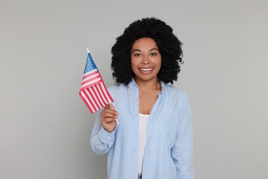 Photo of 4th of July - Independence Day of USA. Happy woman with American flag on light grey background