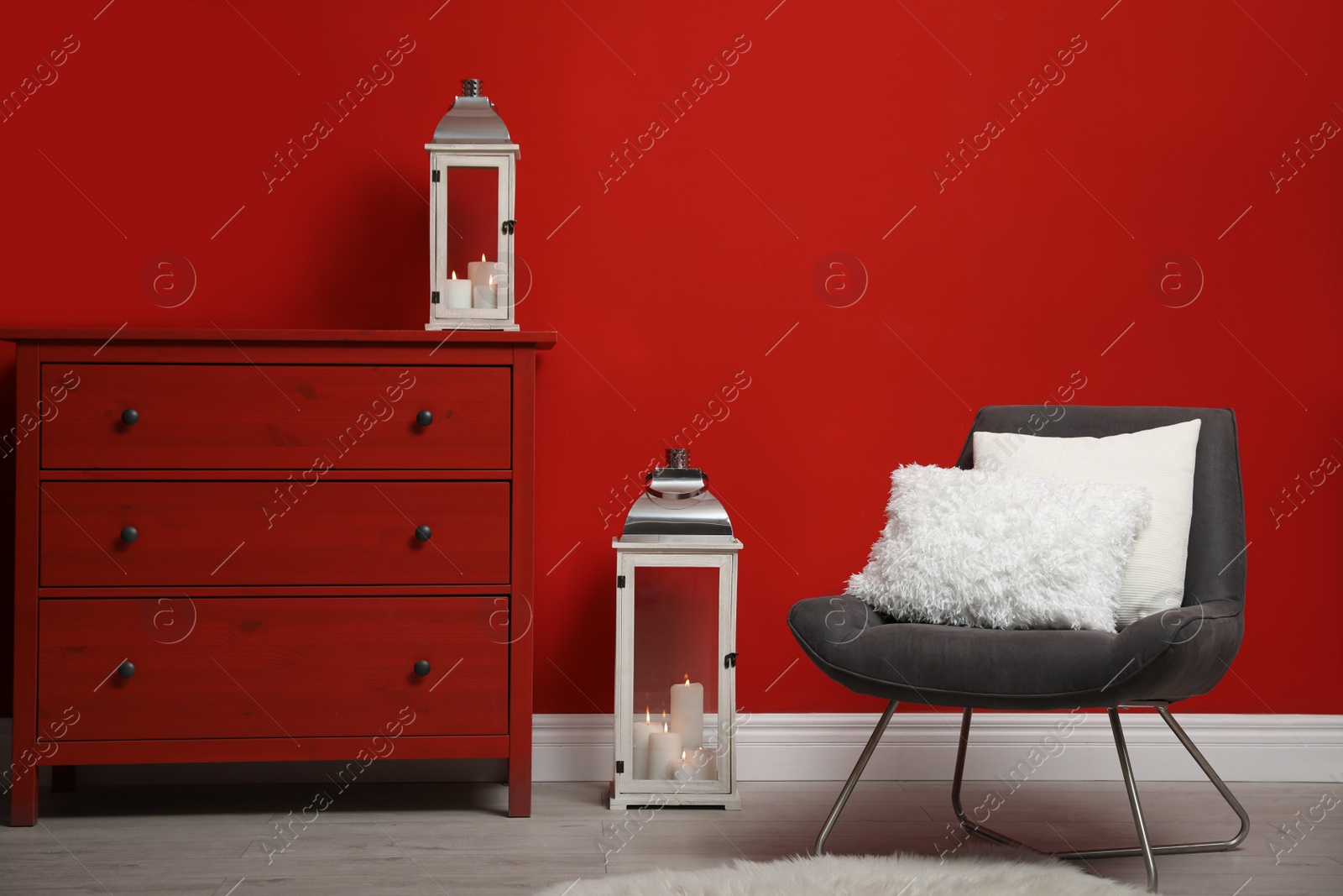 Photo of Soft pillows on armchair near red wall in room