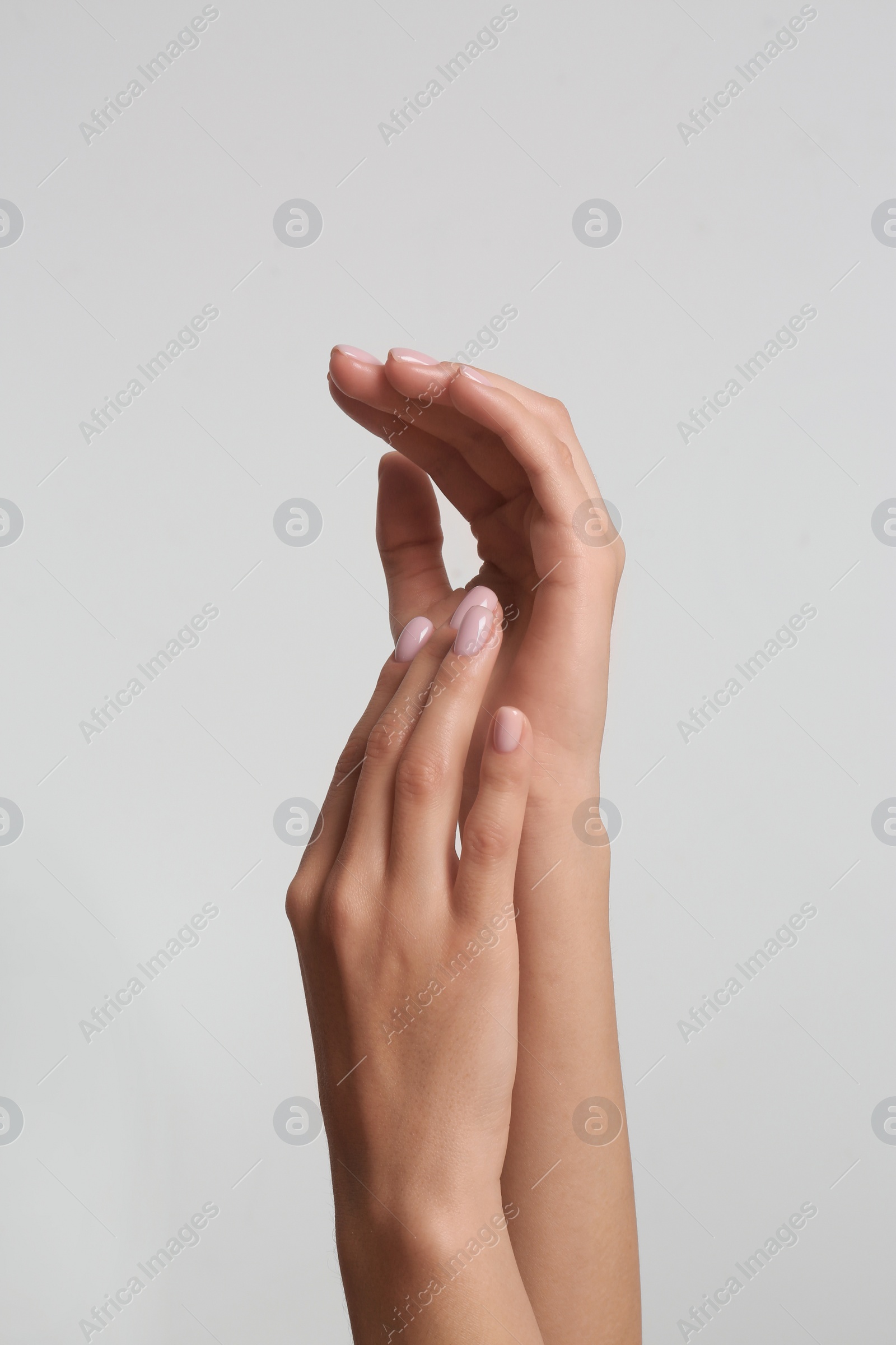 Photo of Woman with beautiful hands on light background, closeup. Spa treatment