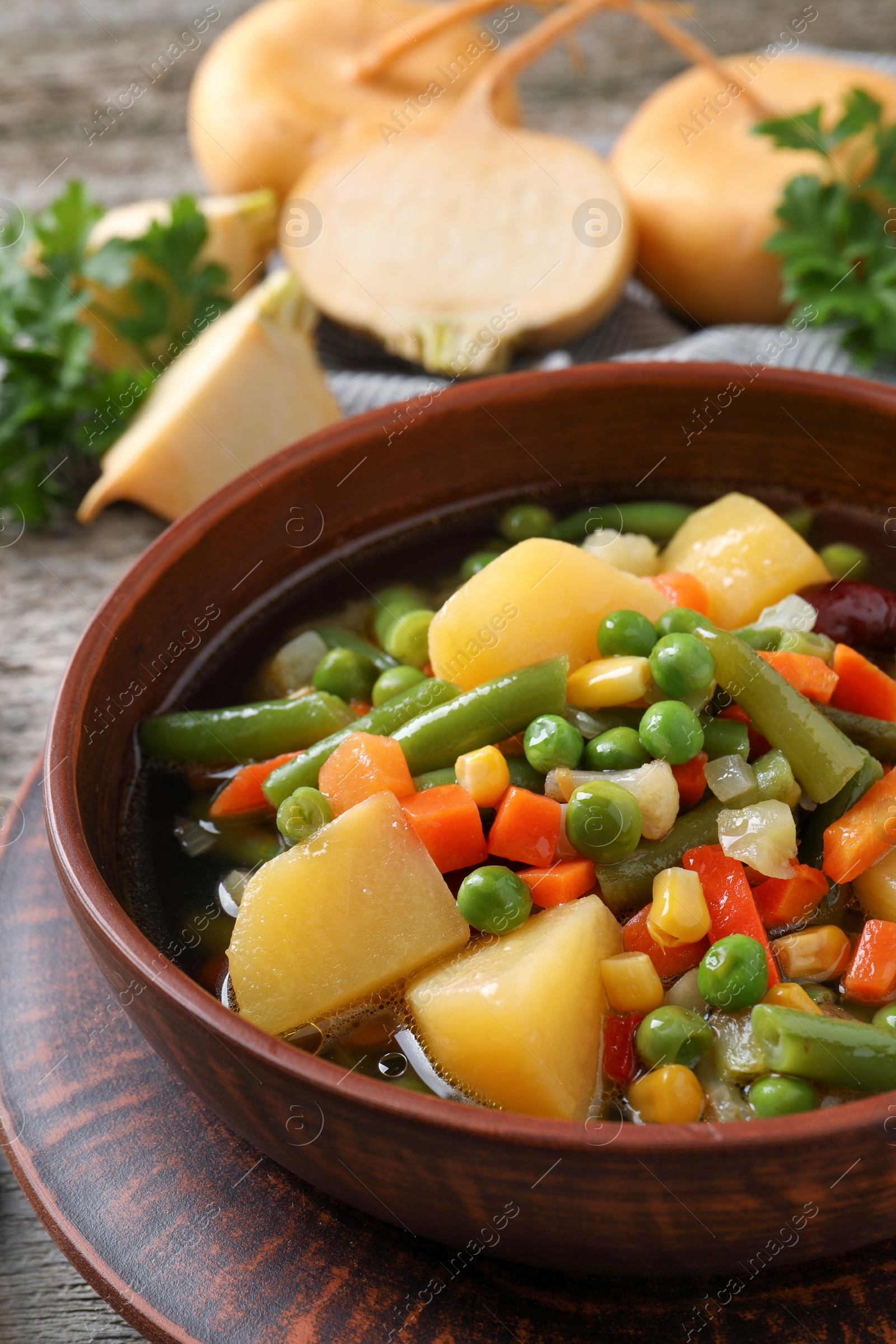 Photo of Bowl of delicious turnip soup on wooden table