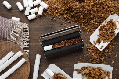 Photo of Flat lay composition with roller and tobacco on wooden table. Making hand rolled cigarettes