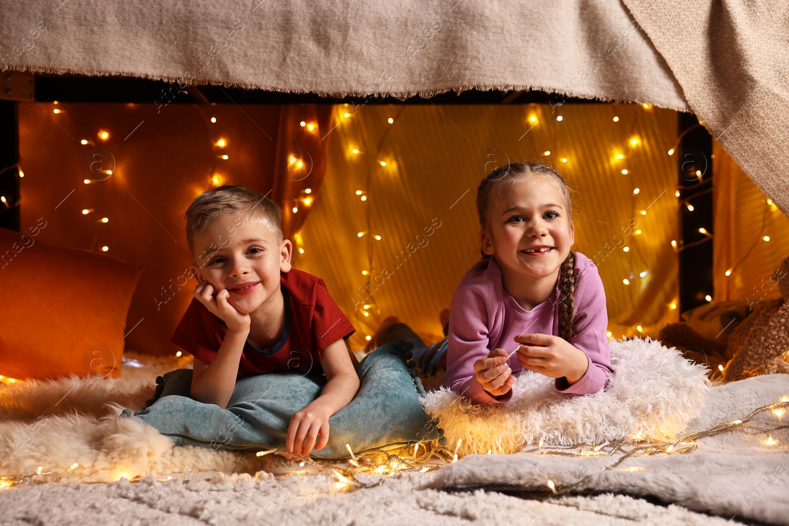 Photo of Happy kids in decorated play tent at home