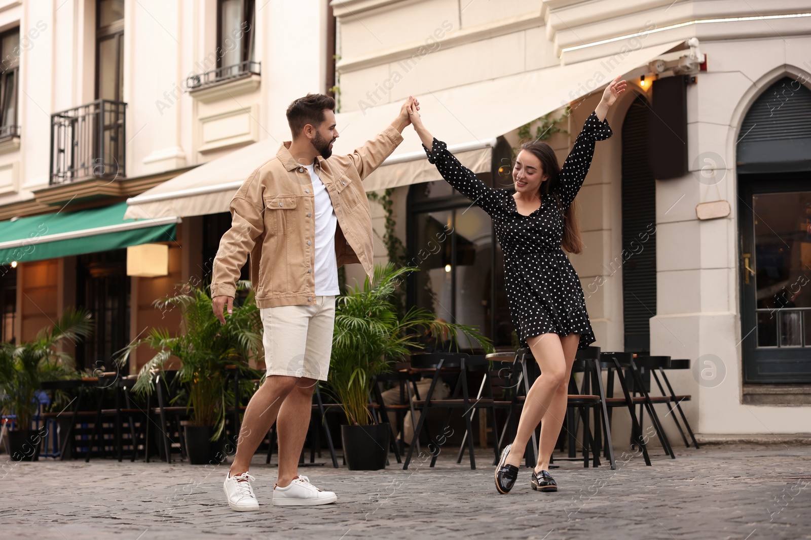 Photo of Lovely couple dancing together on city street