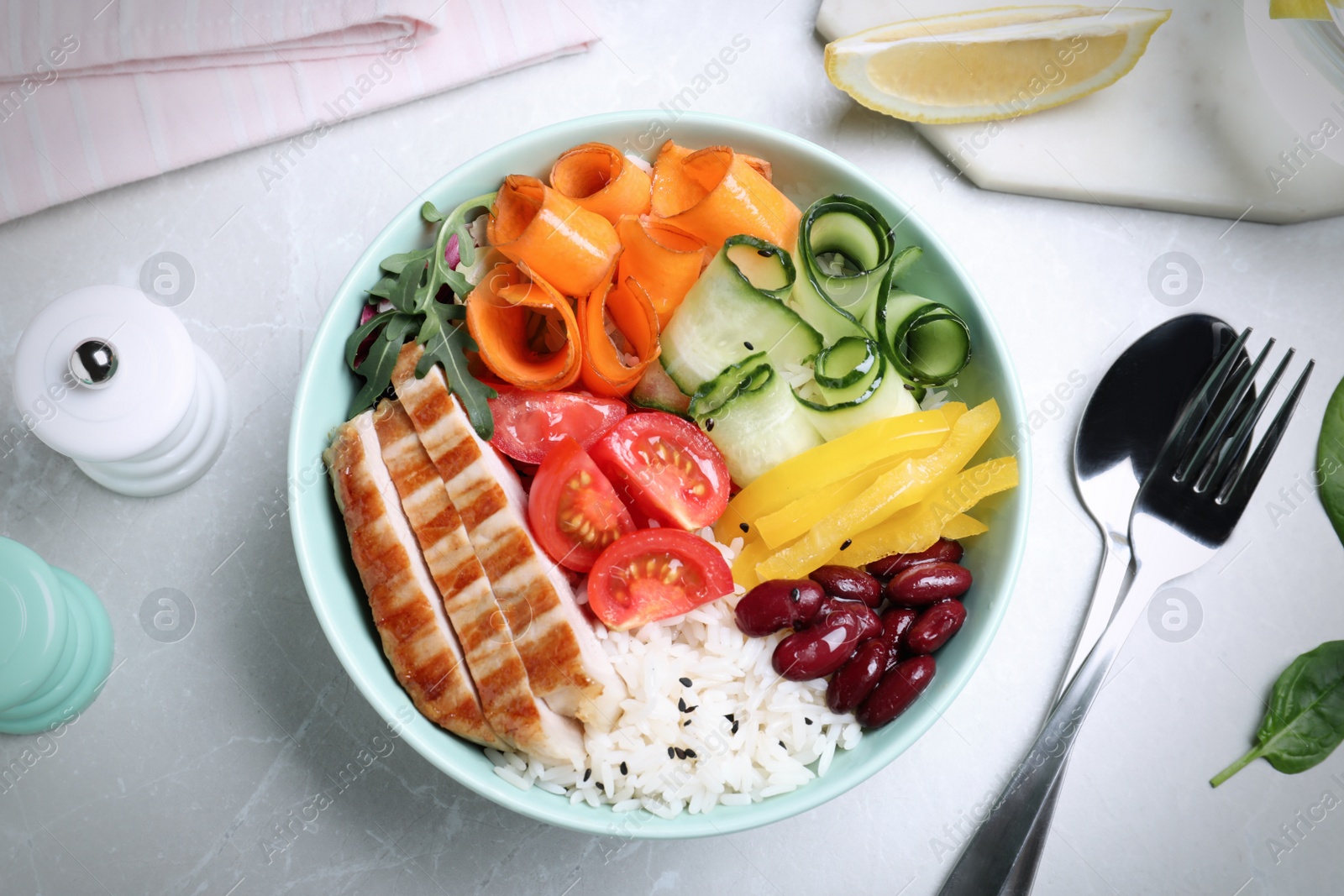 Image of Tasty rice with beans and chicken meat served on light marble table, flat lay. Food photography  