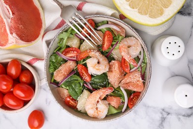 Delicious pomelo salad with shrimps served on white marble table, flat lay