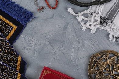 Flat lay composition with Muslim prayer beads, Quran and space for text on grey background