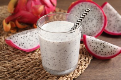 Delicious pitahaya smoothie and fresh fruits on wooden table, closeup