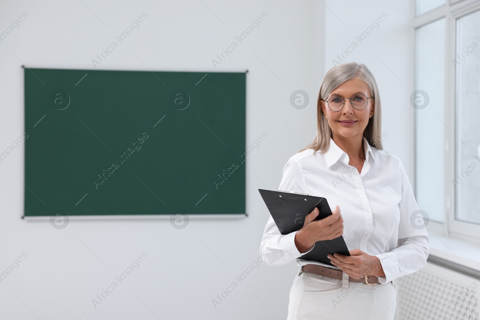 Photo of Portrait of professor with clipboard in classroom, space for text