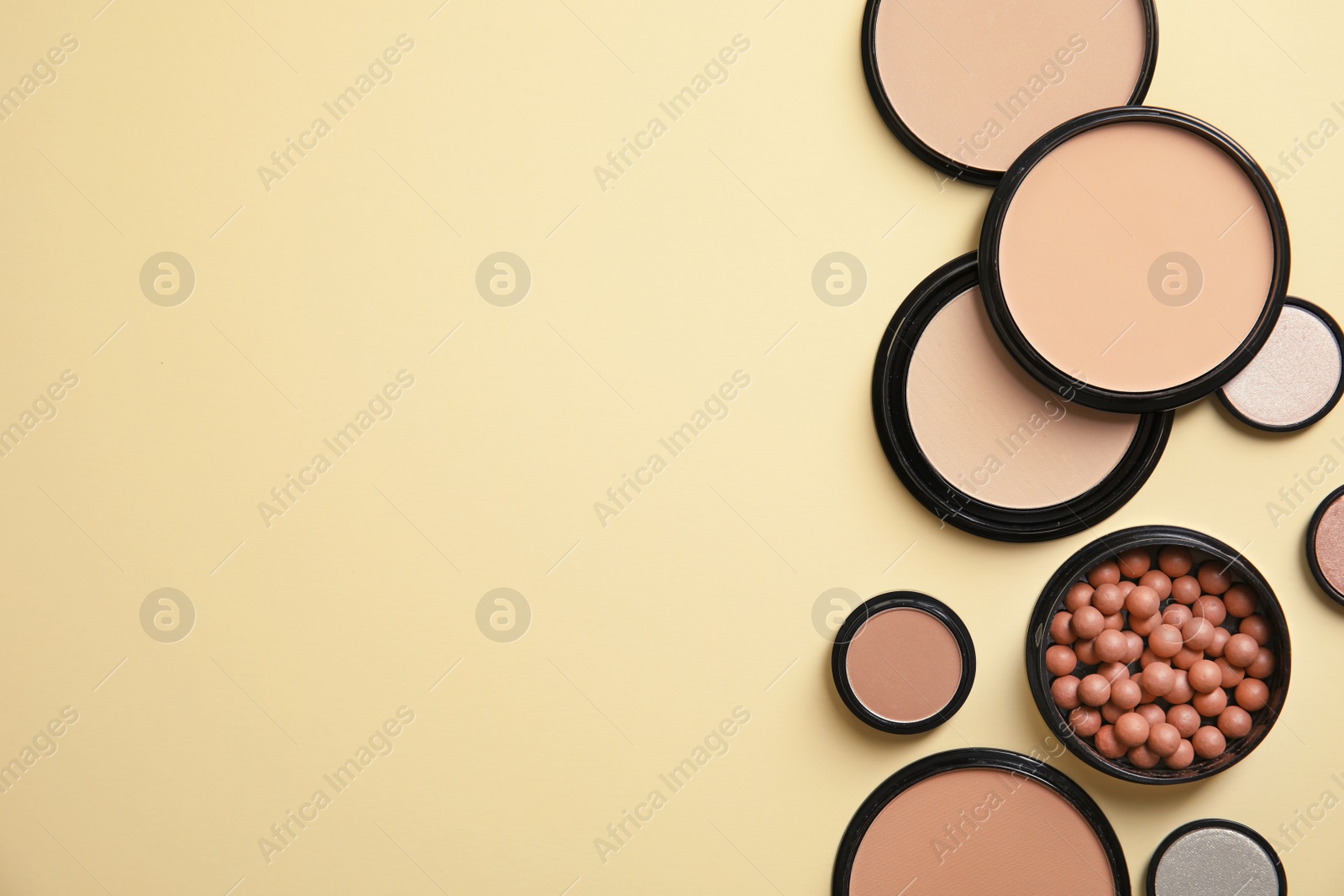 Photo of Flat lay composition with various makeup face powders on color background. Space for text