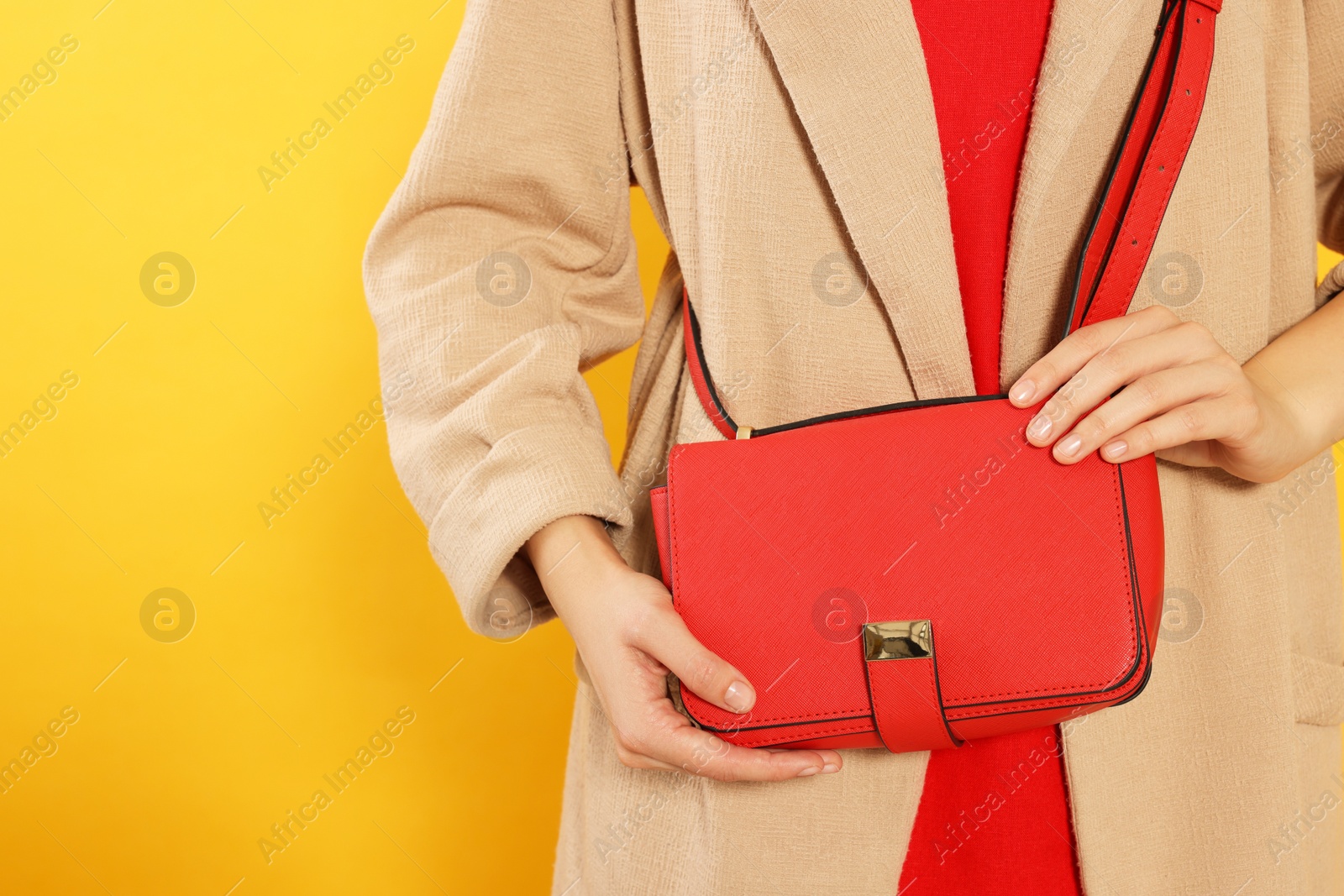 Photo of Woman with stylish bag on yellow background, closeup. Space for text