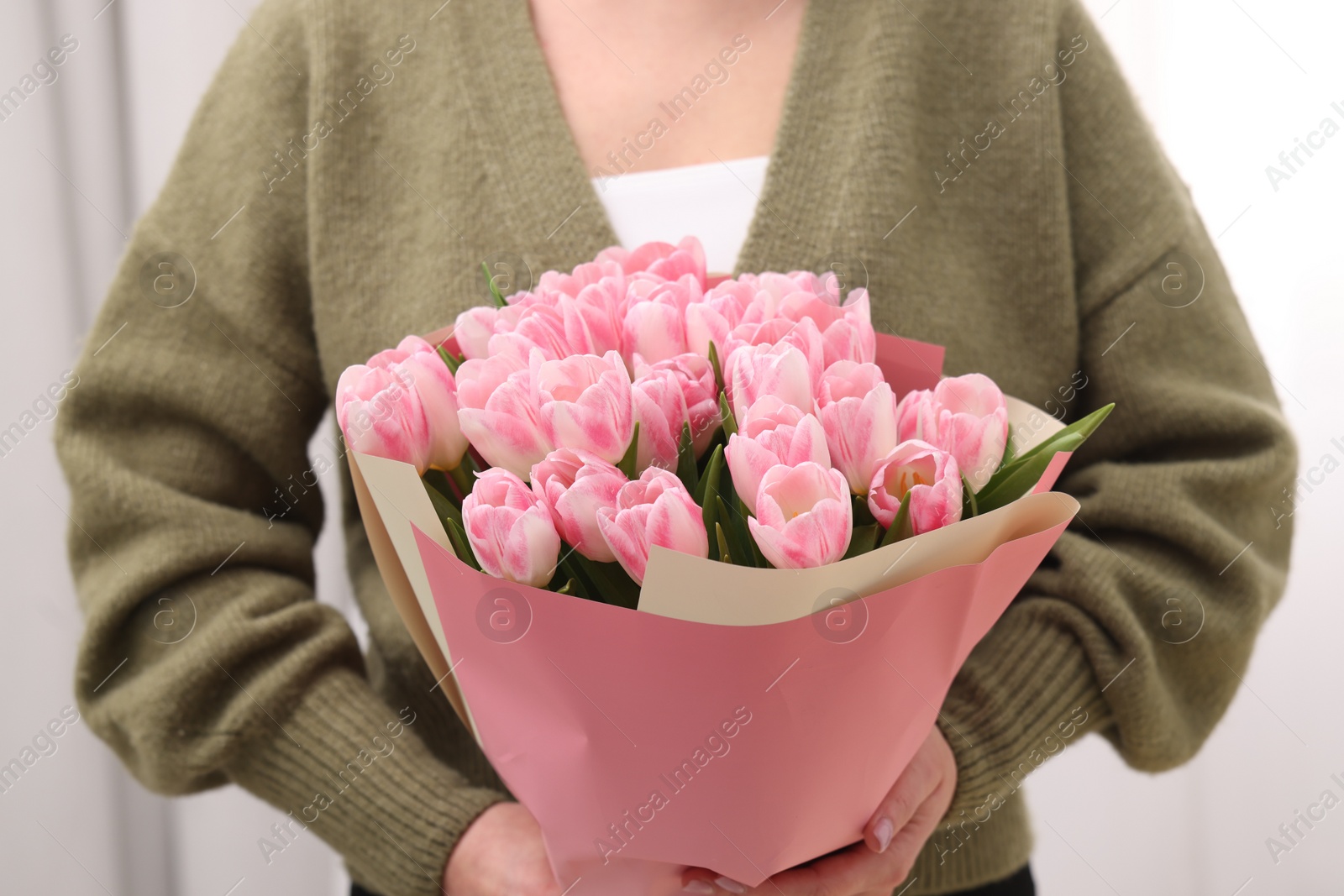 Photo of Woman with bouquet of beautiful fresh tulips on blurred background, closeup