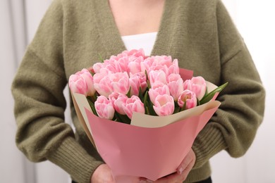 Photo of Woman with bouquet of beautiful fresh tulips on blurred background, closeup