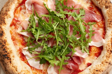 Photo of Tasty pizza with meat and arugula, top view