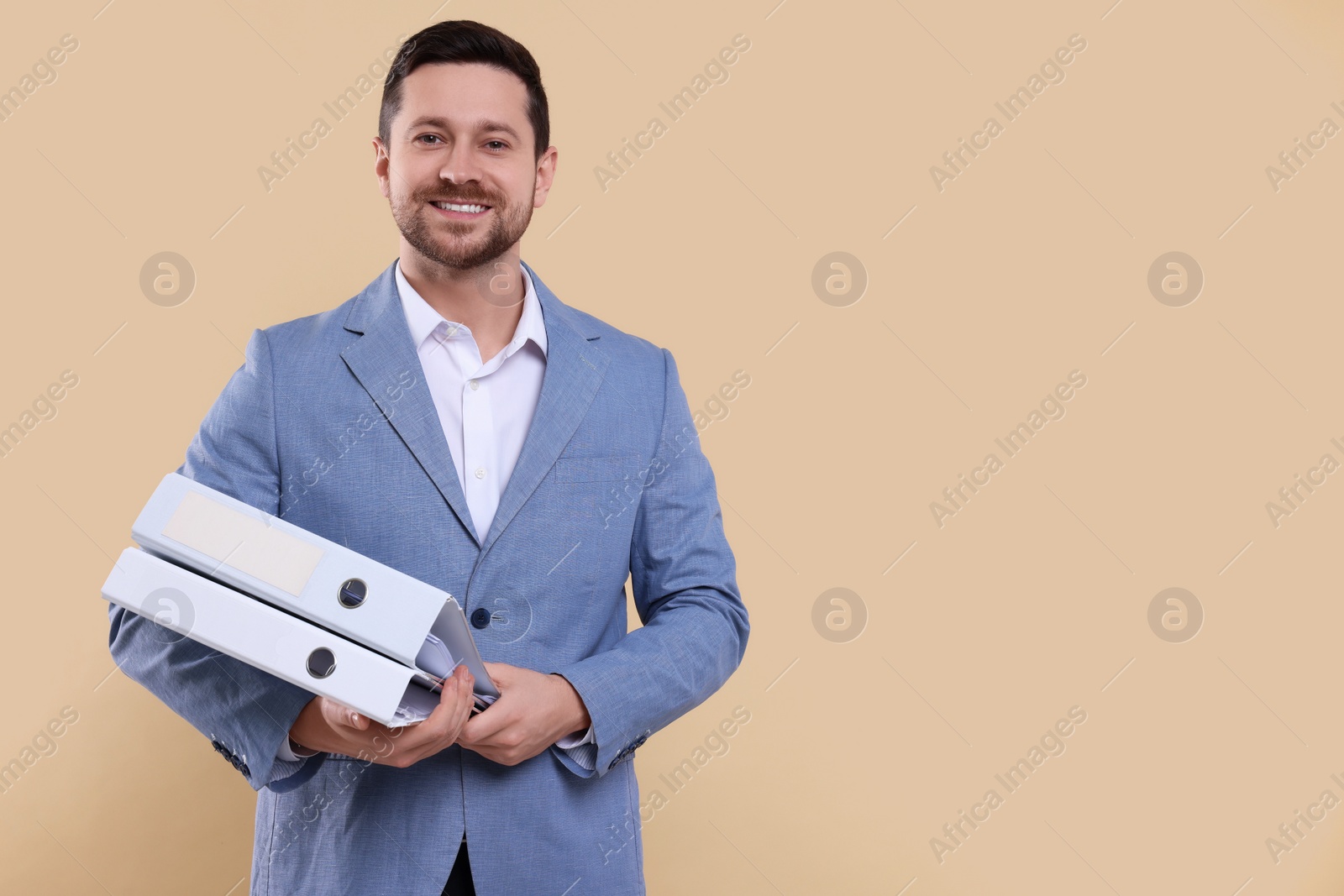 Photo of Happy accountant with folders on beige background. Space for text