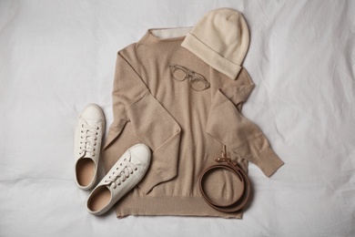 Stylish look with cashmere sweater, flat lay. Women's clothes and accessories on fabric